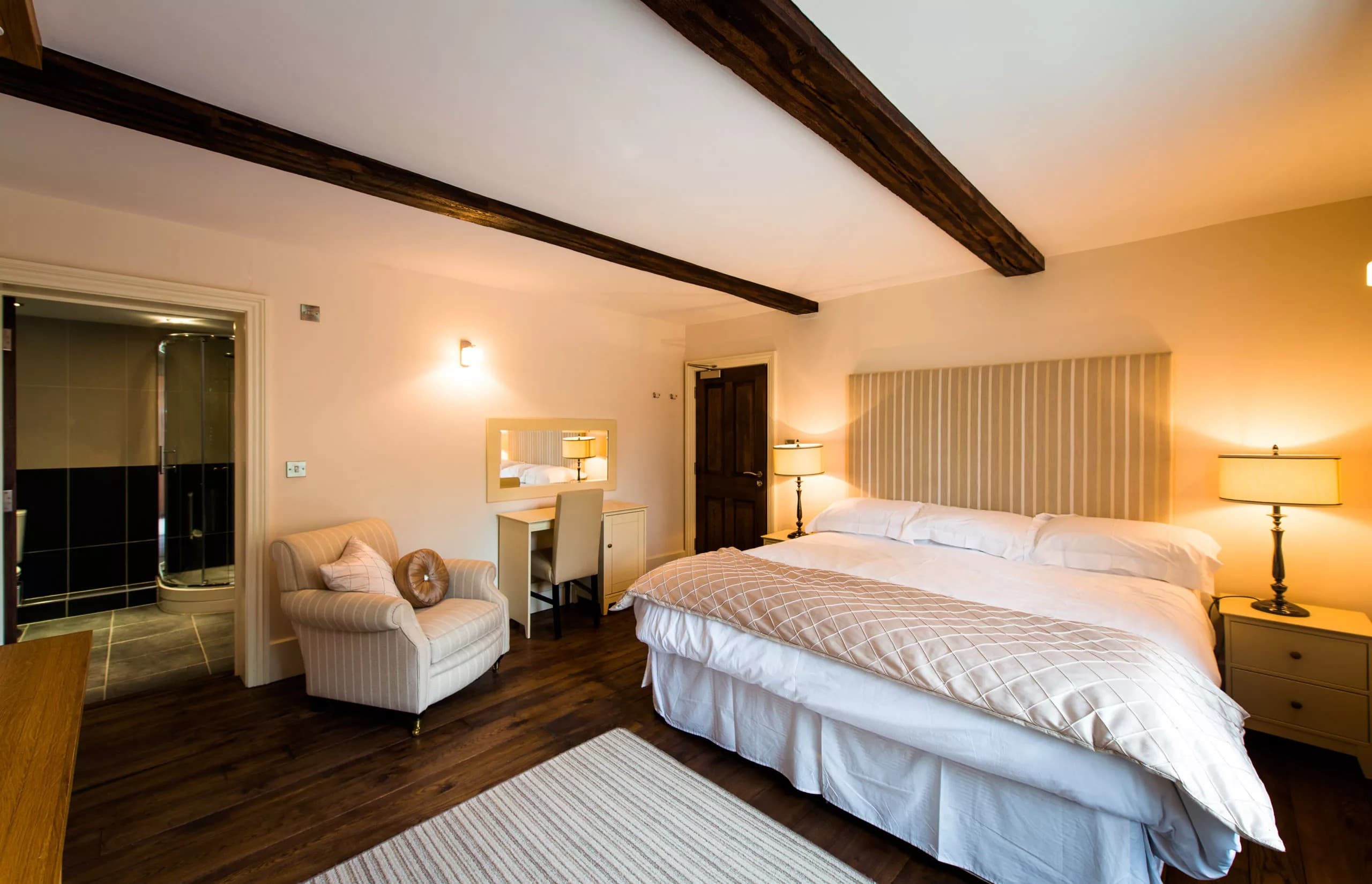 Light-filled room with exposed oak beams and cream furnishings
